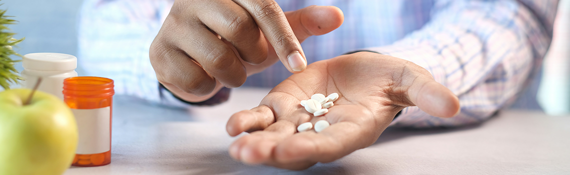 Mann hält Pillen in der Hand