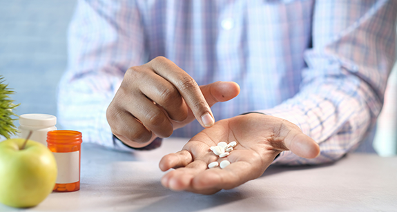 Mann hält Pillen in der Hand