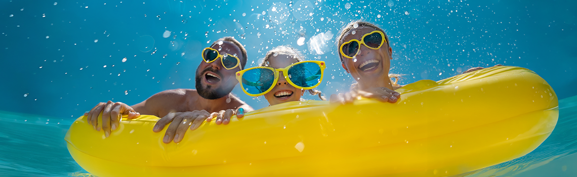 Eine Familie, die Spaß im Wasser auf einem gelben Schwimmreifen hat