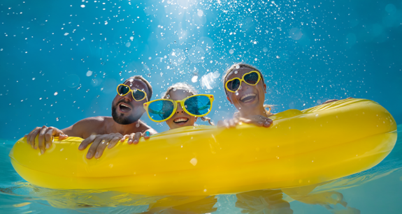 Eine Familie, die Spaß im Wasser auf einem gelben Schwimmreifen hat