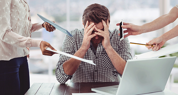 Mann hält sich die Hände vors Gesicht vor Stress