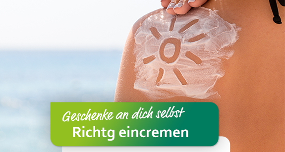 Eine in Sonnencreme gezeichnete Sonne auf der Schulter einer Frau in Nahaufnahme