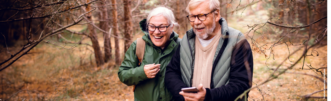 Ein Pärchen läuft im Wald. App Banner Oktober 2025.